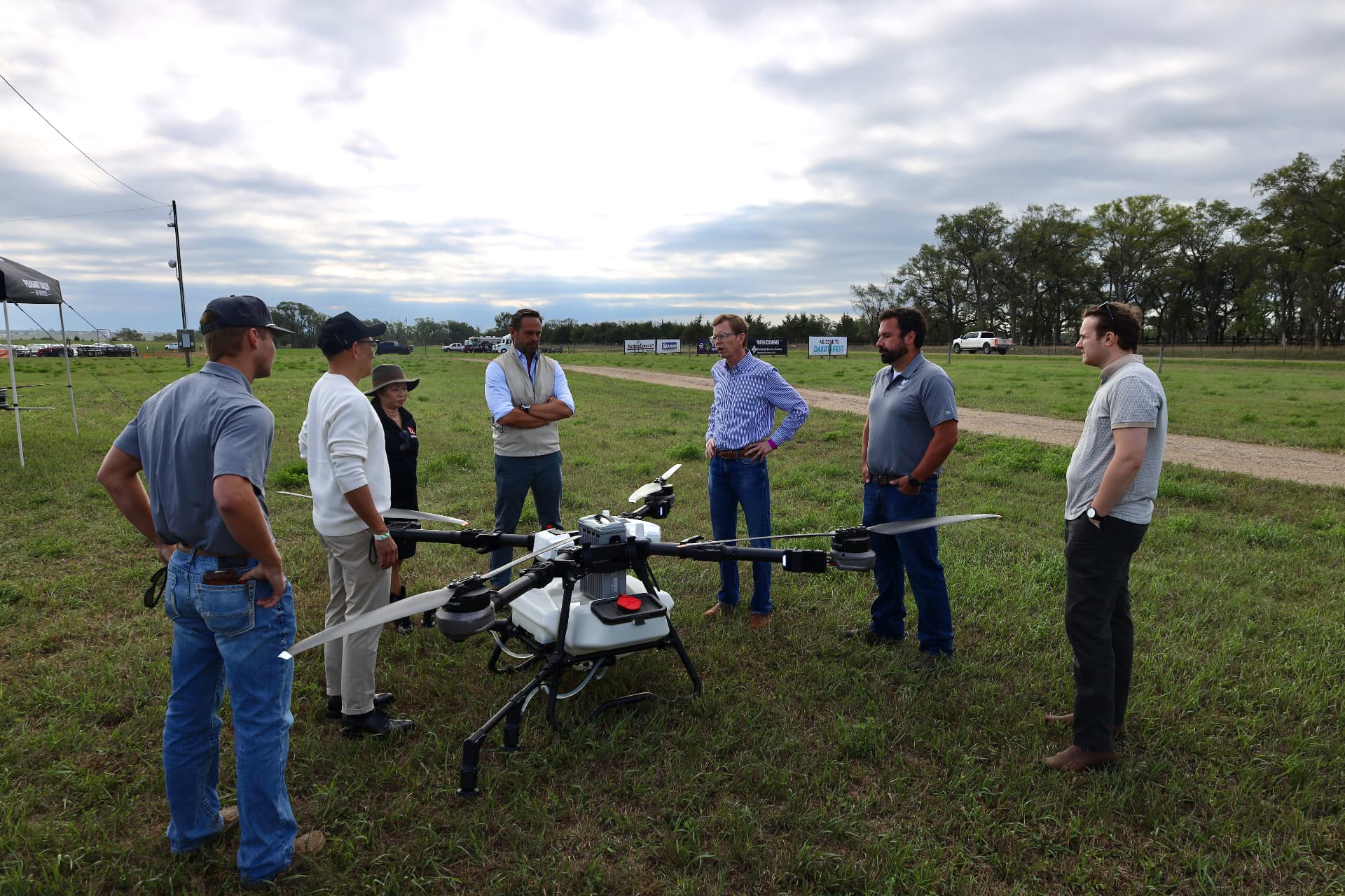 DroneDash Technologies and partner engineers gathered around a large agricultural spraying drone during a technical field briefing
