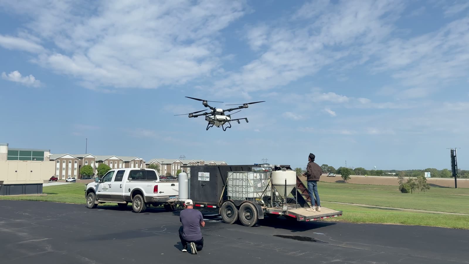 An agricultural spraying drone lifting off from its trailer launch platform during a field demonstration in the United States